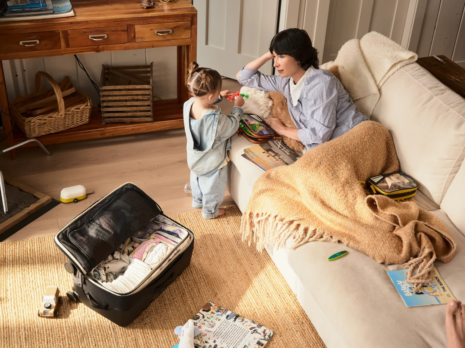 Parent packing a Rollaway at home while a child stands nearby